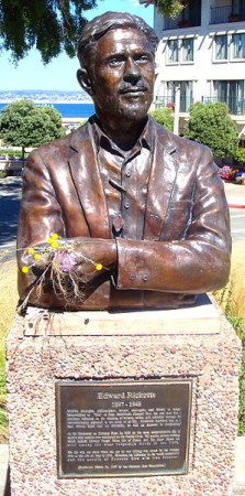 Bust of Edward F. Ricketts’ at the site of his fatal 1948 car-train collision along Cannery Row in Monterey. People continually place flowers in his hand, which holds a starfish. Photo by Amadscientist courtesy of Wikimedia Commons.