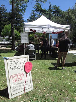 People contributing photos and comments at the Pop Up Museum at San Lorenzo park. Photo courtesy of the Coastal Watershed Council.