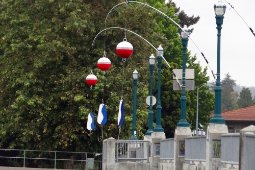 ‘Fishing Rods’ created by Nielsen Design Studios hangs off of the Water St. Bridge. This is one of ten installations created for the Ebb & Flow River Arts Project in June 2015. Photo courtesy and &copy; of Nick Ibarra.