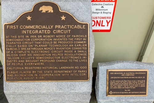 Closeup of the two historical markers to the right of the door in the center of the photo.
